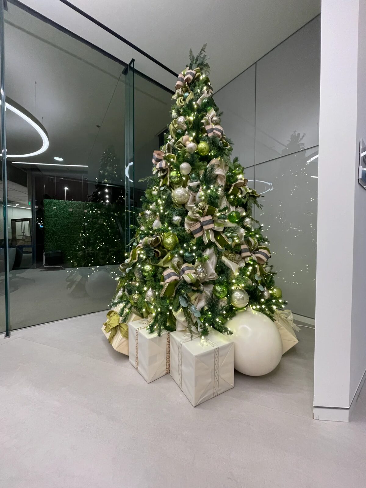 Green and gold decorated tree in a modern lobby